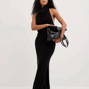 Svart lång klänning - Beställd från NA-KD men trivs inte så jätte bra med öppen rygg men jag insåg att det var för sent att returnera varan.  Ordinarie pris 799kr Har bara haft den liggandes här hemma i sin påse sen december och aldrig andvänt. 