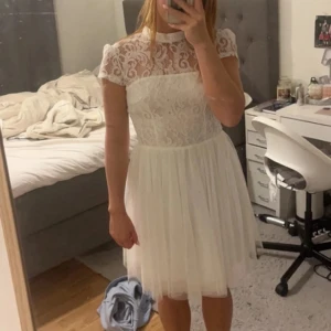 Vit klänning med spets - En jättefin vit klänning med spets upptill, passar perfekt till studenten eller som skolavslutningsklänning, lite öppen i ryggen, helt oanvänd med lapp kvar