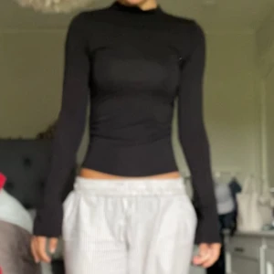 Svart soft touch topp - Långärmad tröja med slitsar i ärmarna från Gina tricot. Söm som ska ”scruncha” ihop tröjan på sidorna, storlek xs. Nypris 299kr. Pris kan disskuteras