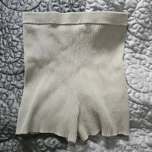 Beige ribbade shorts från H&M - Ett par beige ribbade shorts från H&M. Shortsen har en hög midja och är tillverkade i ett stickat material.