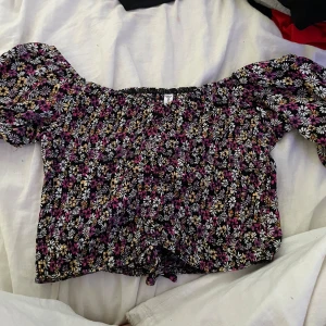 Blommig blus/ tröja - En blommig blus med massa olika färger, den är även lite magtröja ( köparen står för frakt
