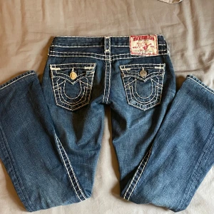 True religion jeans bootcut  - Bootcut true religion jeans vintage modell, white stitch jeans. Äkta. I fint skick bara lite slitna vid fötterna på baksidan. W25 och innerbenslängd är 76,5 men går att lägga ner dem om man vill. 