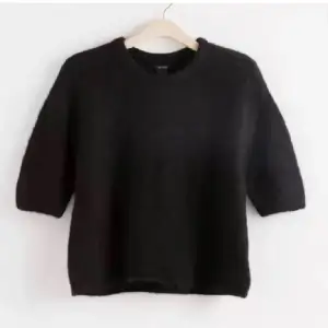 En svart stickad tröja med kortare ärm. Nyskick! Pris kan diskuteras.