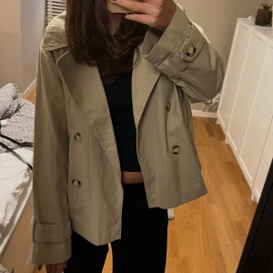 Kort trenchcoat  - Säljer min snygga korta trenchcoat för att jag tyvärr inte använder den tillräckligt. Det är verkligen den perfekta jackan till våren❤️‍🔥köpt för 599kr och använd sparsamt