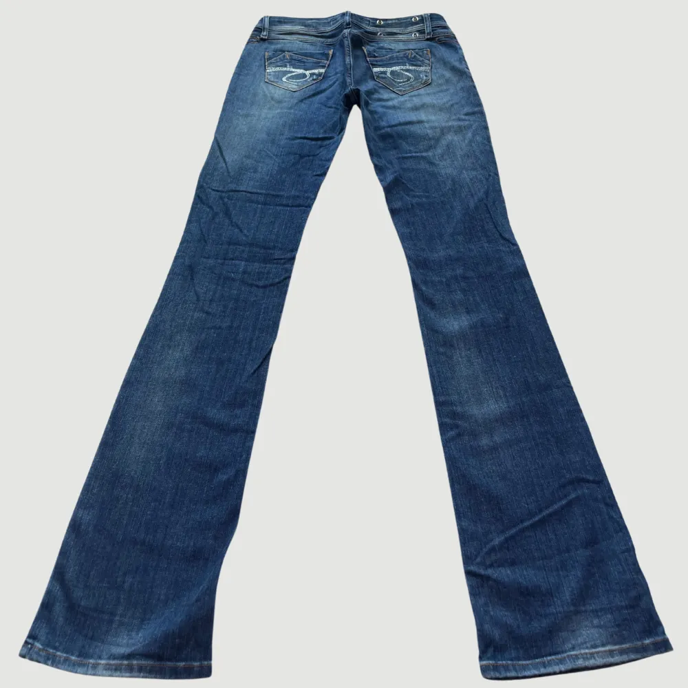 MODELL: Lågmidjade & Bootcut. FÄRG: Blå. STORLEK: 29 enligt lapp. Uppskattad storlek 36. MIDJA RAKT ÖVER: 39 cm. MIDJEHÖJD: 19 cm. TOTALLÄNGD (FRÅN MIDJAN): 111 cm.. Jeans & Byxor.