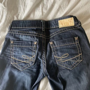 Snygga lågmidjade jeans  - Lågmidjade jeans i mörkblå denim, från märket EDC. De är i storlek 27 vilket motsvarar ungefär st 38 