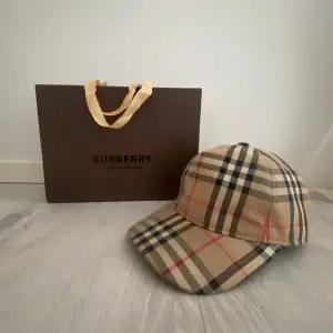 Burberry keps, väldigt bra skick, box och påse medkommer. Kepsen är storlek m. Bara att kontakta mig om du har en fråga gällande kepsen eller pris!👊👊