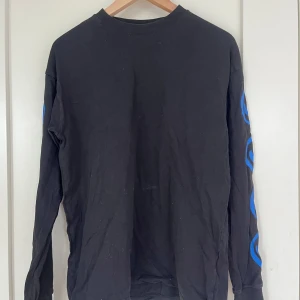 svart långärmad tröja - så snygg svart långärmad tröja från junkyard med blåa smileys på båda ärmarna. Storlek S. Knappt använd💞