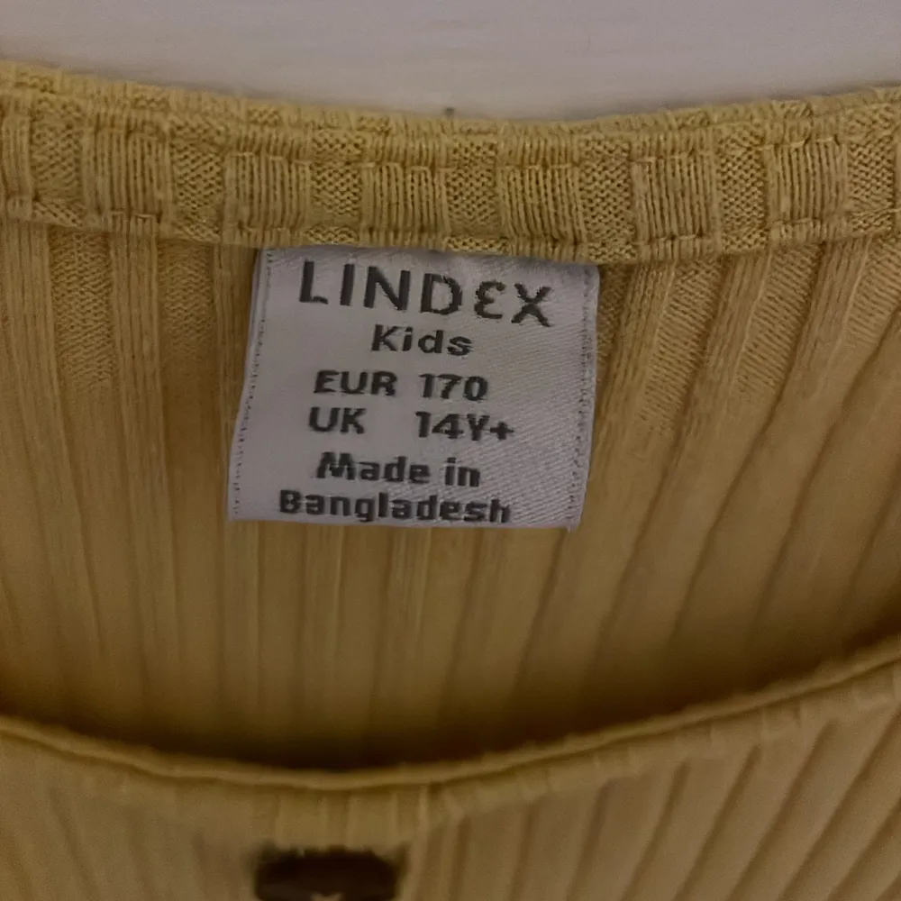 Gul långklänning från Lindex i fint skick, knappt använd och har bruna knappar på mitten. Köpare betalar frakt. Klänningar.