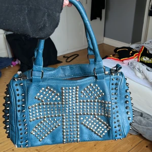 cool väska  - den har väldigt mycket tecken på användning. men alla stenar och nitar sitter kvar. dragkedjan e trasig och även den lilla dragkedjan på det lilla facket inuti så därför säljer jag den billigt. skriv till mig om du är intresserad/prisförslag🥰