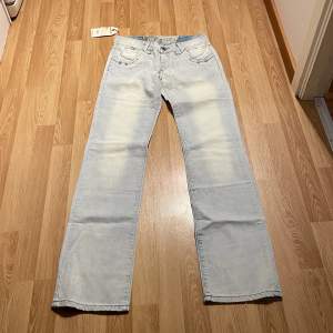 (37) lågmidjade ljusblåa bootcut jeans med specialfickor, från ligao helt nya med lappar kvar. Midjemått rakt över: 36cm, innerbenslängd: 84cm skulle säga strlk 36❤️
