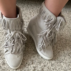 Snygga klackar med fransar - Säljer nu mina snygga casadei liknande skor med kilklack och fransar🤍🤍i mycket bra skick och otroligt sköna, enda defekten är att skosnöret på ena skon är lite slitet (kan skicka bild🥰) Storlek 41, perfekta till våren!🤍🤍🥰kom gärna med prisförslag!