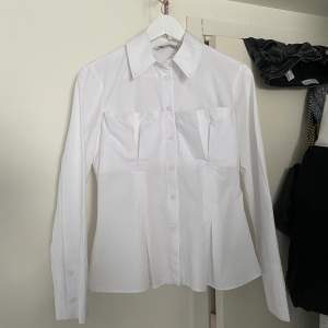 Super fin unik vit skjorta från Zara. Använd fåtal gånger och i perfekt skick. Korsett liknande detalj. Liten i storlek.