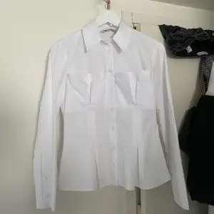 Super fin unik vit skjorta från Zara. Använd fåtal gånger och i perfekt skick. Korsett liknande detalj. Liten i storlek.