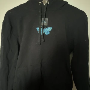 Hoodie  - Hoodie från the cool elephant i storlek S!❤️ Med en liten blå fjäril på framsidan och bestörte på ryggen, hoodie är svart. Nypris ca 700kr
