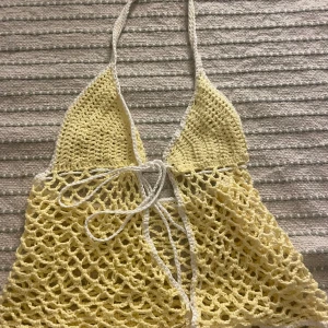 Virkad söt top - Egengjord. Knyts på framsidan.Virkad med pastel gul garn och vit garn på bordern. Garn: Bomull Knyts med band på framsidan och runt halsen. Justerbar.🤍 