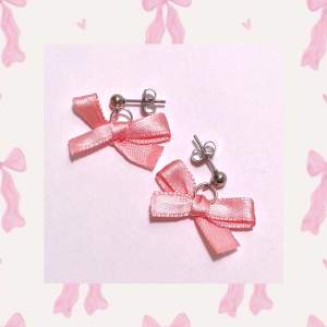 Super söta örhängen med rosa band. Rostfritt och nickelfritt  -handgjort och oanvänt- Kontakta innan köp för frakt med frimärke (15kr)