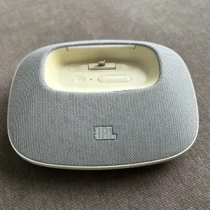 En grå och vit högtalare från JBL! Den passar med iPhone och iPod. Finns flera ingångar för sladdar och USB. Den är lite äldre så sladden kan behöva vara inkopplad!  Pris går absolut att diskutera!