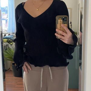 Ribbad långärmad  - En väldigt fin långärmad, svart och ribbad tröja. V-ringad, nästan aldrig använd och lång vid ärmarna. 