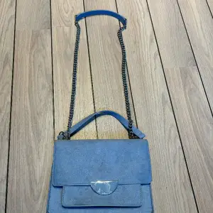 Fin handväska med justerbar axelrem  Färg: ljusblå 