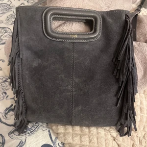 Maje väska  - Säljer min maje väska i bra skick. Den har lite små defekter vid handtaget men annars skulle jag säga att den är i bra skick. Äktehetsbevis ingår. Den är i mellan modellen. Säljer för 1000+frakt🥰priset kan dock diskuteras