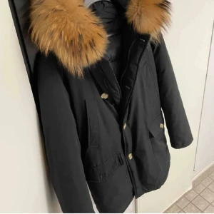 Enos jacka - Svart pälsjacka i s herr, pälsen går även att ta bort.   Jackan har även ficka med zip, håller värme bra.  Defekt som inte läggs märke till som är en knapp på ena fickan annars i ny ny skick och rökfri.  Retail 3000.  Skickas & möts. Lund