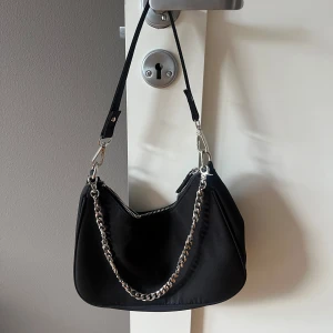 Snygg handväska med kedja  - Super fin handväska från BikBok med en kedja som man kan ha runt axeln eller bara hänga på väskan, väldigt bra skick, som ny då den inte kommit till användning💓 väskan har även en liten inre ficka💕