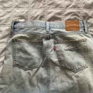Jeanskjol - En jeanskjol från Levis. Den är blå och i storlek 27. Den är i bra skick. 