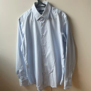 Hugo Boss Skjorta - En ljusblå skjorta från Hugo Boss | Storlek 40, Medium/Large, regular fit | Fint skick förutom en mycket liten defekt på ena ärmen som syns på sista bilden  Fler skjortor, pikétröjor och annat till bra pris finns på min profil!