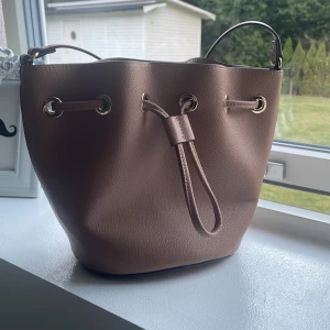 Ljus brun väska - En ljusbrun axelväska. Ej använd.