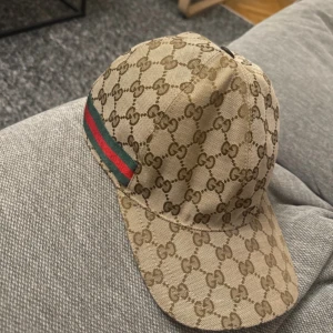 Gucci canvas keps - Jag säljer nu min beiga Gucci canvas keps. Inköpt i Danmark 2022. Har nu ingen användning för den och vill sälja. Såklart äkta, kom privat för fler bilder och kvitto. Storlek L. Mvh 