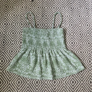 Topp - Säljer denna ljusgröna topp med vita blommor på i bra skick från Gina. I storlek XS❣️