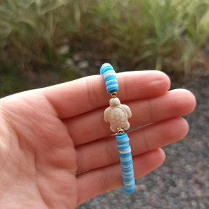 Sommar rea  - Ett blått armband med en ljus sköldpadda, säljs ut under sommar rean. 