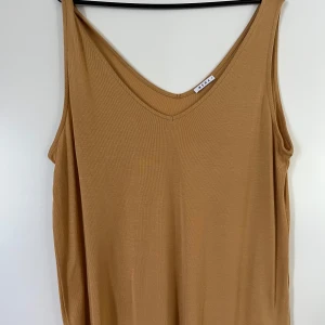 Topp Wera M - Senapsgul topp från Wera i storlek M. I mycket god skick, knappt använt. Osäker på material då klippt av lappen, misstänker viskos.   Mått:  Längd ca 67 cm Byst ca 60 cm Midja ca 53 cm Materialet är elastiskt.   Plagget kommer från ett djur- och rökf