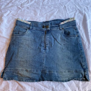 Jeanskjol  - Jätte fin jeanskjol i bra skick från Cinema. Har små blomdetaljer högst upp på sidorna. Jätte fina knappar och dragkedja. Tryck gärna på köp nu💕