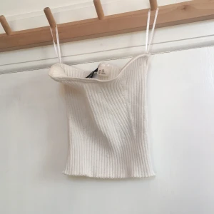 Vit tubmagtröja. - Bra skick, har band så att den kan hållas uppe på en galge.