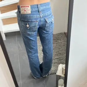 Bootcut jeans från true religion.  Har ett lappat hål längst ner på benet annars nyskick. Midjemått:39 tvärs över  Innerbenslängd: 84 cm