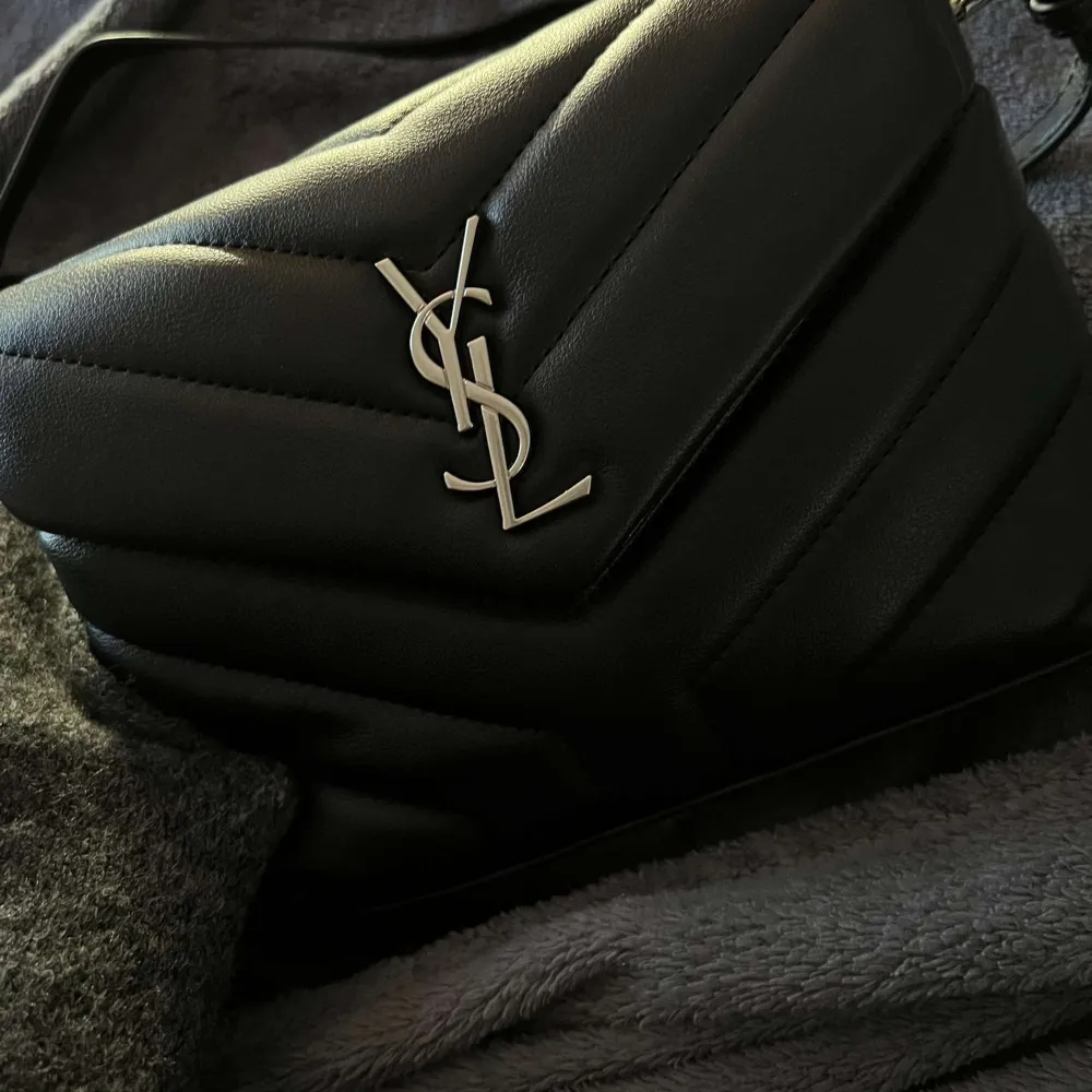 Säljer denna Yves saint Laurent väska i den lilla modellen. Haft denna i något år men den är så sparsamt och fått använd. Har ej kvitto , box eller något som kan garantera äktahet då den är köpt second hand och därav lågt pris. Allt stämmer in på den.. Väskor.