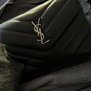 Yves saint Laurent  - Säljer denna Yves saint Laurent väska i den lilla modellen. Haft denna i något år men den är så sparsamt och fått använd. Har ej kvitto , box eller något som kan garantera äktahet då den är köpt second hand och därav lågt pris. Allt stämmer in på den.