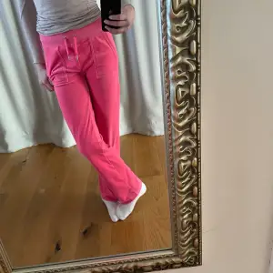 Hot pink juicy couture byxor med fickor.  De är lite uppsydda men de är sydda så att det ska vara enkelt att sprätta upp:) Innerbenslängd: 81cm uppsydda, 83 vanligt Midjemått (tvärsöver): 32 Tidigare användning: hyfsat använda men fortfarande fina:)