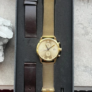 Triwa sort of black gold chrono - I väldigt bra skick 38mm  Denna Sort of Black klocka kommer med en guldig boett, gjord av rostfritt stål. Klockan levereras med två olika klockarmband så man kan ändra utseende efter humör. 