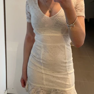Klänning - Jättefin vit klänning som är perfekt till student. Skolavslutning eller konfirmation! Den är använd en gång och det var på min konfirmation så inprincip helt oanvänd. Sitter som en xs/s