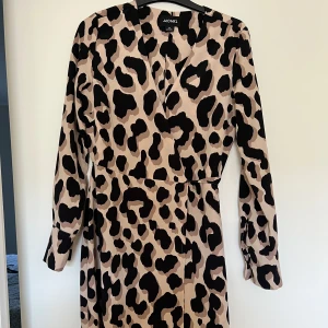 Klänning  - Klännig med leopard mönster, slutar strax över anklarna.   Använd 1-2 gånger.