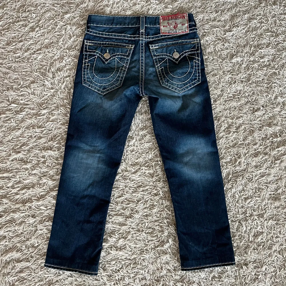 Ett par ”ricky super t” true religion jeans i size 32, dope wash och bra skick bortsett från ett minimalt märke som visas på 5e bilden. 43cm midja,  75cm innerbenslängd, 21cm benöppning. Övriga funderingar hit tha DM #true. Jeans & Byxor.