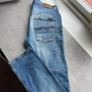 Jeans Från Nudie. Jeansen är i bra skick med endast några små fläckar. Jeansen har en sliten look och en riktigt najs fade! Storleken är 32/32 men är små i storleken.