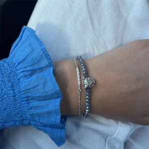 Armband med berlock - Säljer ett egetpärlat armband med både pärlor och berlock från Tarifa i Spanien. Jag kan ändra till andra pärlor om det betyder att det säljs. Aldrig använt. Har 3 extraberlocker också!!