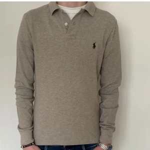 Polo Ralph Lauren Pike - Här säljs en beige långärmad Ralph Lauren pikétröja. Plagget är i ett 10/10 skick, känns som ett helt nytt plagg. Slim fit passform o är i storlek S.