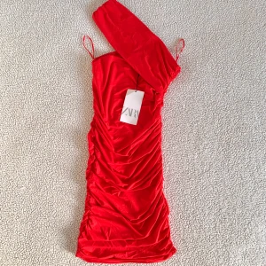 ZARA slinky kort röd klänning - Otroligt snygg kort röd ”slinky” klänning från ZARA. Ny med tags kvar, utan anmärkningar. Har dessvärre inga bilder med klänningen på.
