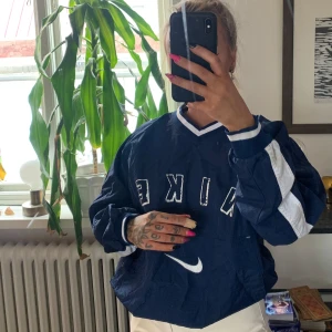 Vintage Nike tröja  - Snygg vintage Nike tröja i mörkblå färg, med fickor på framsidan! Supersnygg och i ”prassligt” material, så det är som en tunnare jacka i tjockleken.