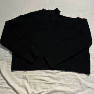 Svart stickad tröja - Svart stickad tröja med öppen Axel på ena sidan Strl. XL Aldrig använd